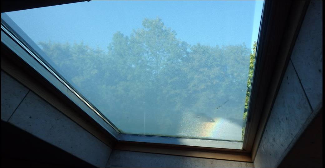 Regenbogen und Regentropfen auf den Dachfenstern