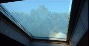 Regenbogen und Regentropfen auf den Dachfenstern